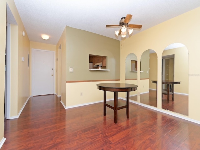 unfurnished dining area with dark hardwood / wood-style flooring, a textured ceiling, and ceiling fan