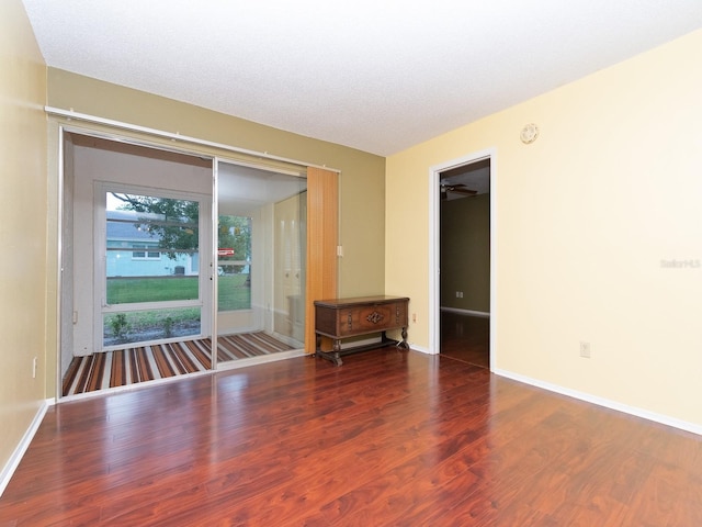 spare room featuring a textured ceiling and dark hardwood / wood-style floors