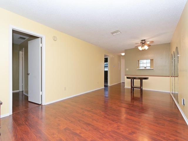 spare room featuring ceiling fan, a textured ceiling, and dark hardwood / wood-style floors