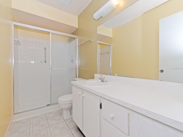 bathroom featuring vanity, toilet, and a shower with shower door