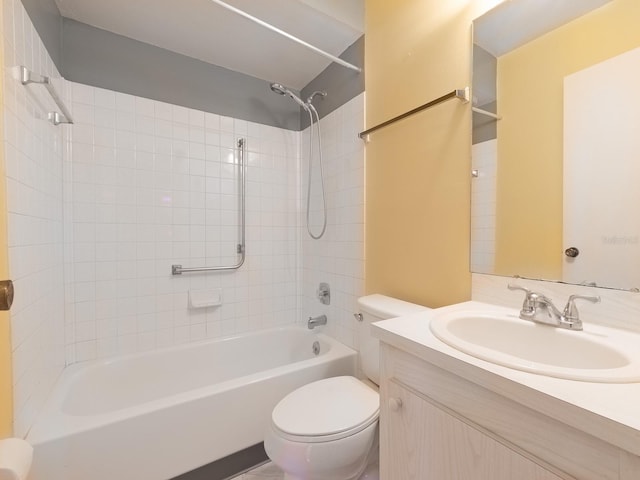 full bathroom featuring vanity, tiled shower / bath combo, and toilet