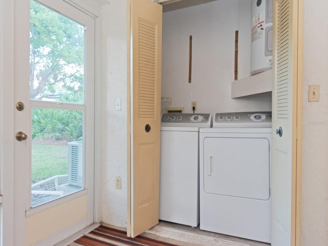 laundry room with water heater, independent washer and dryer, and plenty of natural light