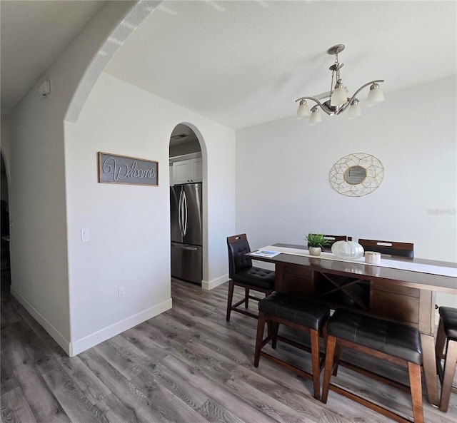 dining room featuring dark hardwood / wood-style flooring and a notable chandelier