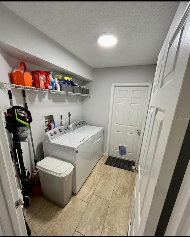 clothes washing area featuring a textured ceiling and washing machine and dryer