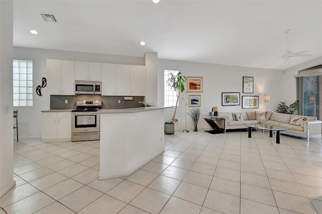 kitchen featuring stainless steel appliances, ceiling fan, white cabinets, and light tile patterned floors