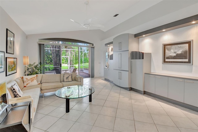 tiled living room with ceiling fan and vaulted ceiling