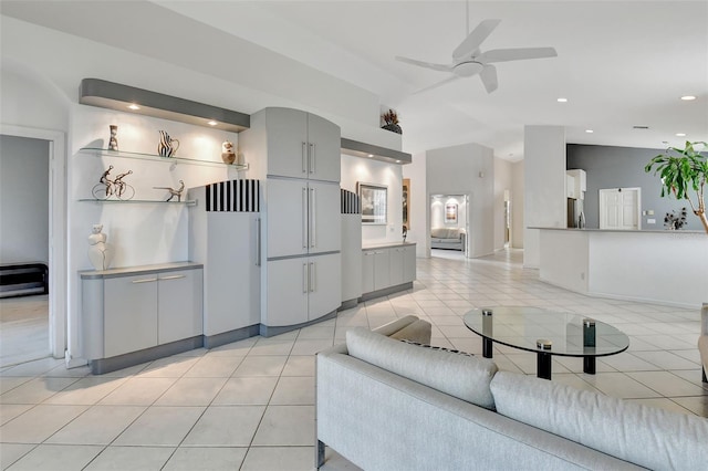 tiled living room featuring ceiling fan and vaulted ceiling