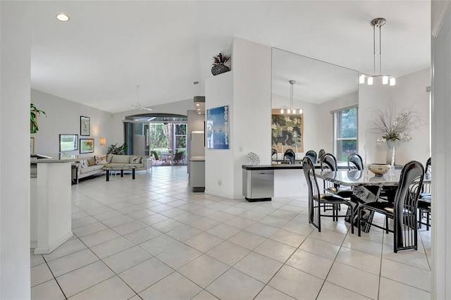 tiled dining room featuring ceiling fan with notable chandelier and vaulted ceiling