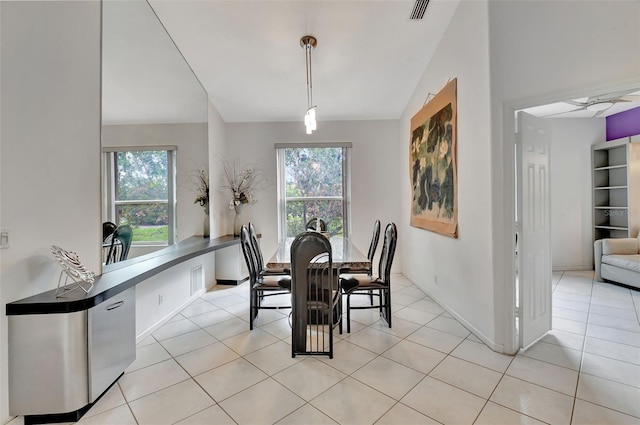 dining room with plenty of natural light, lofted ceiling, and light tile patterned floors