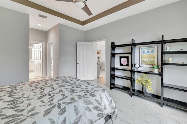 bedroom featuring light wood-type flooring, ceiling fan, and connected bathroom