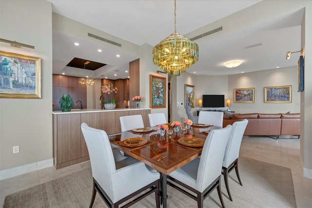 dining area featuring a notable chandelier, light tile patterned floors, and sink