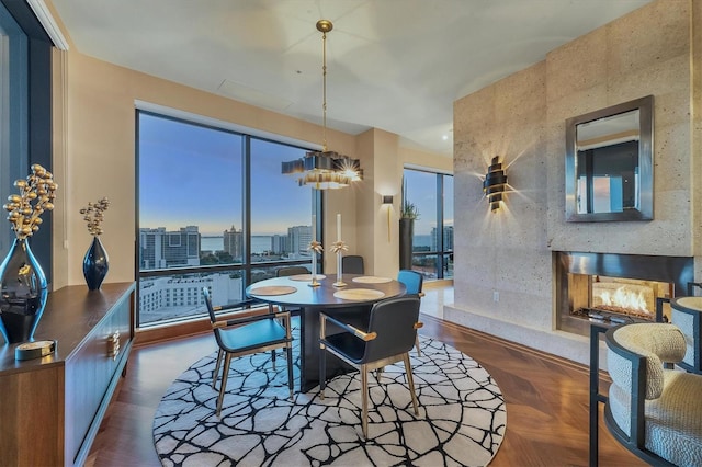 dining room featuring a premium fireplace and dark parquet floors