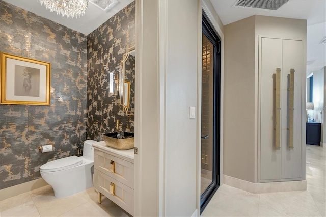 bathroom featuring toilet, tile patterned flooring, and a notable chandelier