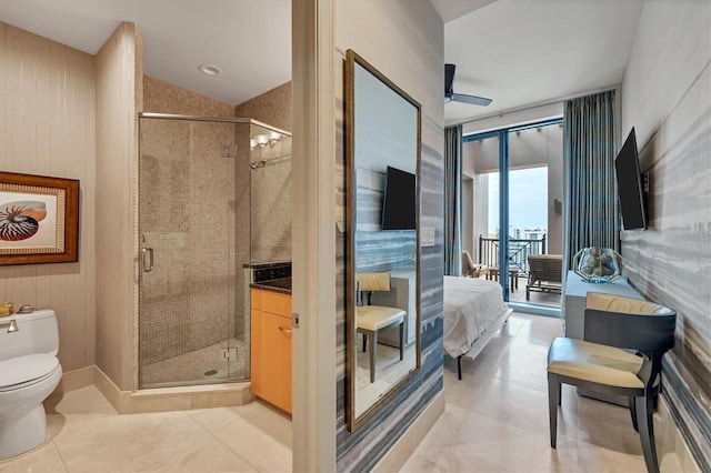 bathroom featuring ceiling fan, a wall of windows, walk in shower, toilet, and vanity