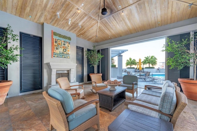 living room featuring wooden ceiling and exterior fireplace