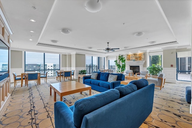 living room featuring ceiling fan, crown molding, and a tray ceiling