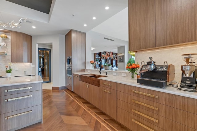 kitchen featuring decorative backsplash, sink, and light parquet floors