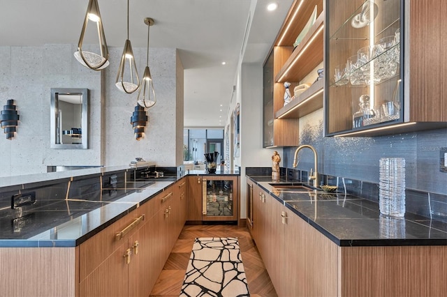 kitchen featuring sink, decorative light fixtures, kitchen peninsula, beverage cooler, and light parquet flooring