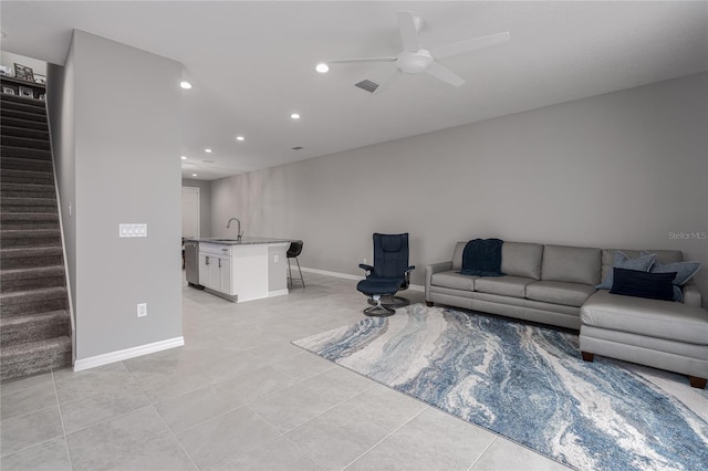 living room featuring sink, light tile patterned flooring, and ceiling fan