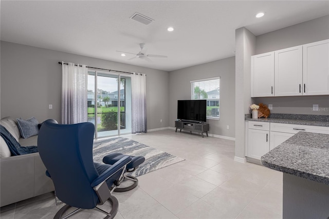 tiled living room with ceiling fan