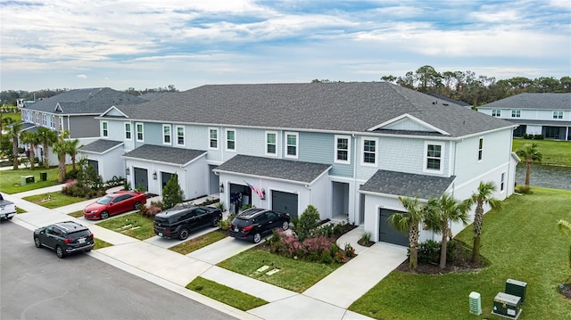 view of property with a residential view, a shingled roof, an attached garage, and driveway
