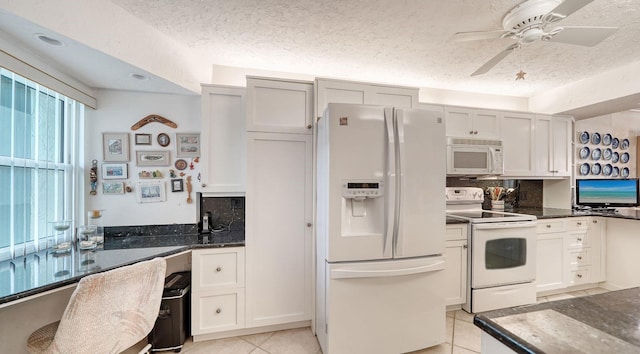 kitchen with a textured ceiling, decorative backsplash, light tile patterned floors, and white appliances