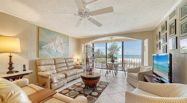 living room featuring light tile patterned floors, a textured ceiling, and ornamental molding