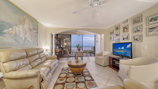 tiled living room with ceiling fan and ornamental molding