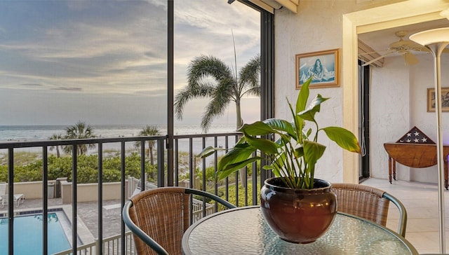 balcony with a water view and ceiling fan