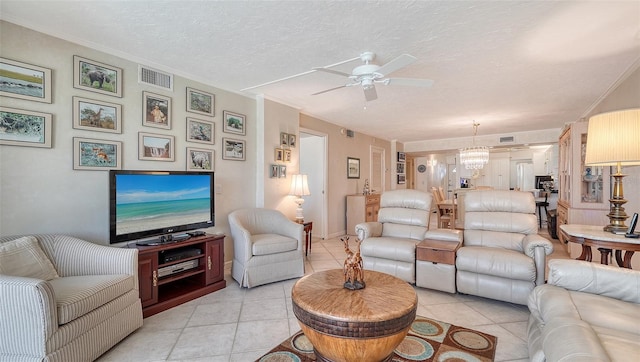 living room featuring ceiling fan with notable chandelier, light tile patterned flooring, a textured ceiling, and ornamental molding