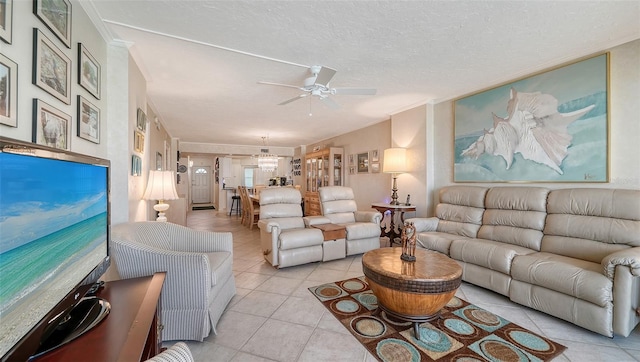 living room with ceiling fan, crown molding, light tile patterned floors, and a textured ceiling