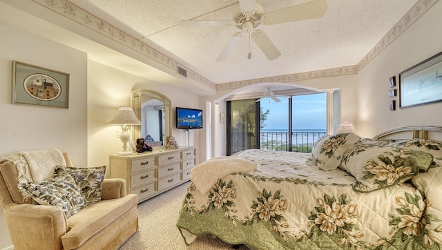 bedroom featuring a textured ceiling, ceiling fan, access to exterior, and light carpet