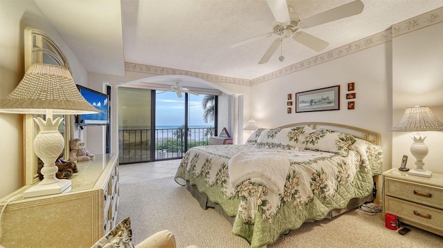 bedroom with access to exterior, ceiling fan, light colored carpet, and a textured ceiling