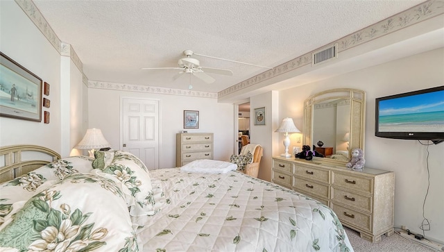 bedroom with ceiling fan, a textured ceiling, light carpet, and a closet