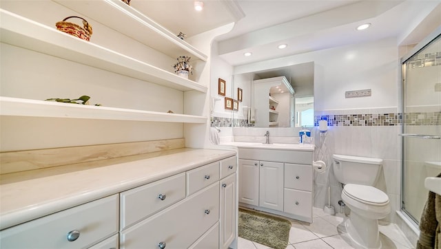 bathroom featuring vanity, tile patterned flooring, toilet, tile walls, and an enclosed shower