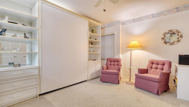 sitting room featuring light carpet, a textured ceiling, and ceiling fan