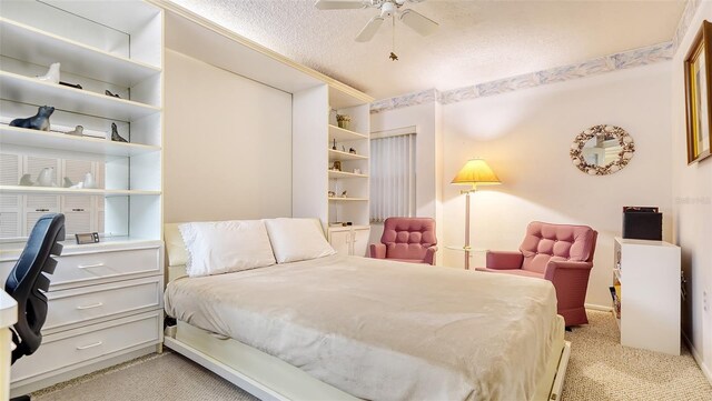 carpeted bedroom with ceiling fan and a textured ceiling