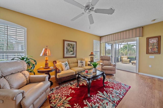 living room with a textured ceiling, hardwood / wood-style flooring, and ceiling fan