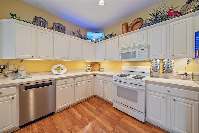 kitchen with white cabinetry, white appliances, and light hardwood / wood-style floors