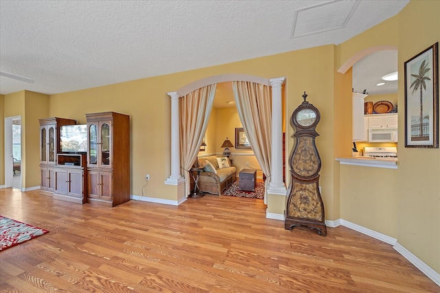 interior space with a textured ceiling and light hardwood / wood-style flooring