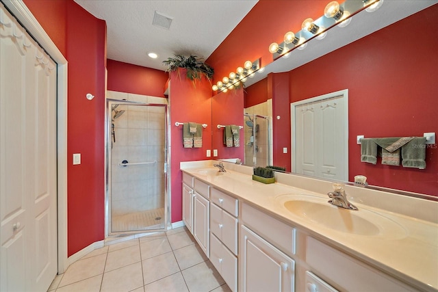 bathroom featuring vanity, tile patterned floors, walk in shower, and a textured ceiling