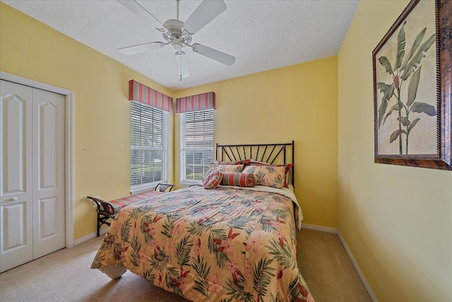 bedroom featuring a closet, ceiling fan, a textured ceiling, and light colored carpet