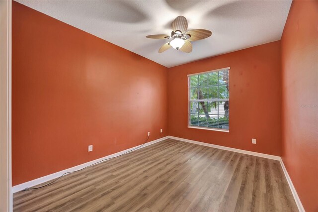 empty room with wood-type flooring, ceiling fan, and a textured ceiling