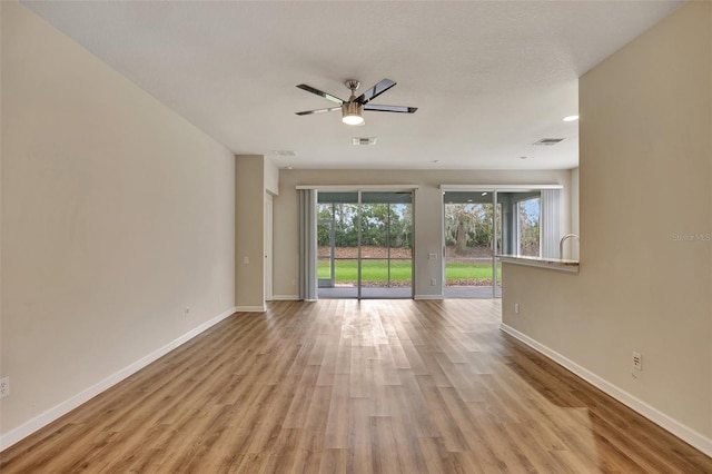 empty room with ceiling fan and light hardwood / wood-style floors