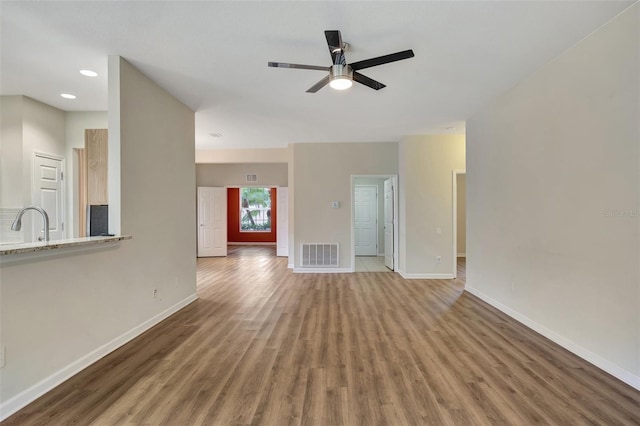 unfurnished living room featuring hardwood / wood-style flooring and ceiling fan