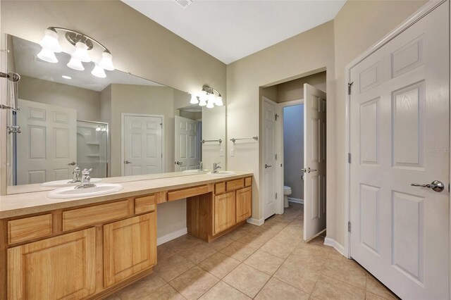 bathroom featuring vanity, walk in shower, tile patterned flooring, and toilet