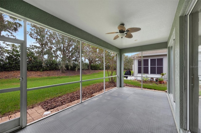 unfurnished sunroom with ceiling fan