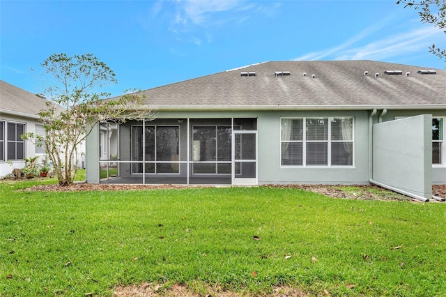 back of property with a sunroom and a lawn