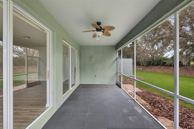 unfurnished sunroom featuring ceiling fan