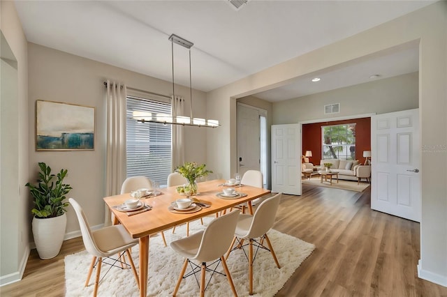 dining area featuring light hardwood / wood-style floors and a notable chandelier